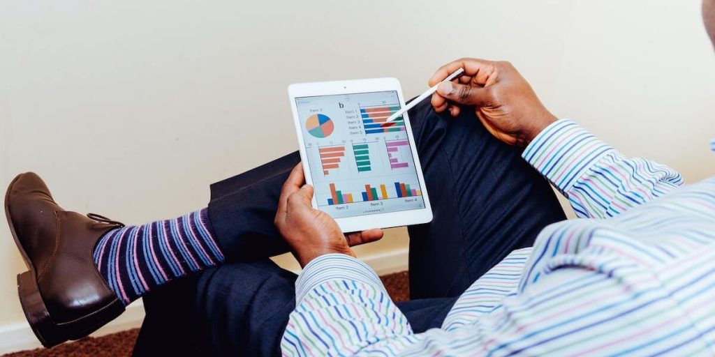 Homem analisa resultados de sua estratégia de marketing em tablet.