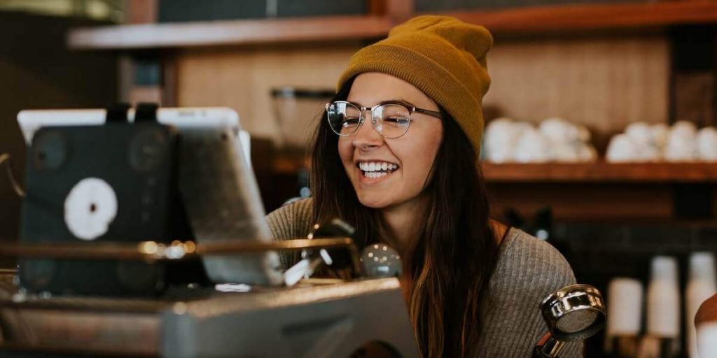 mulher prepara café usando máquina de expresso em cafeteria local. 