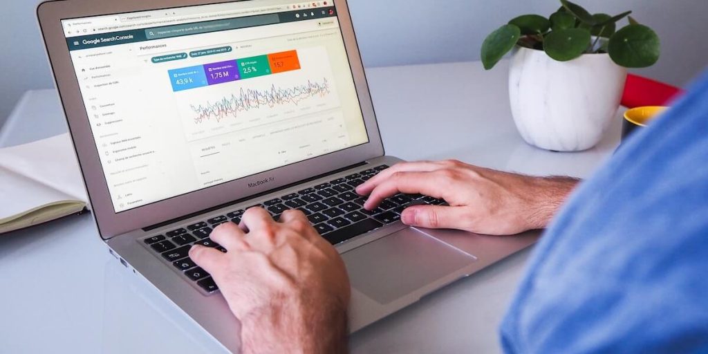 homem analisando relatório do Google Search Console em notebook. 