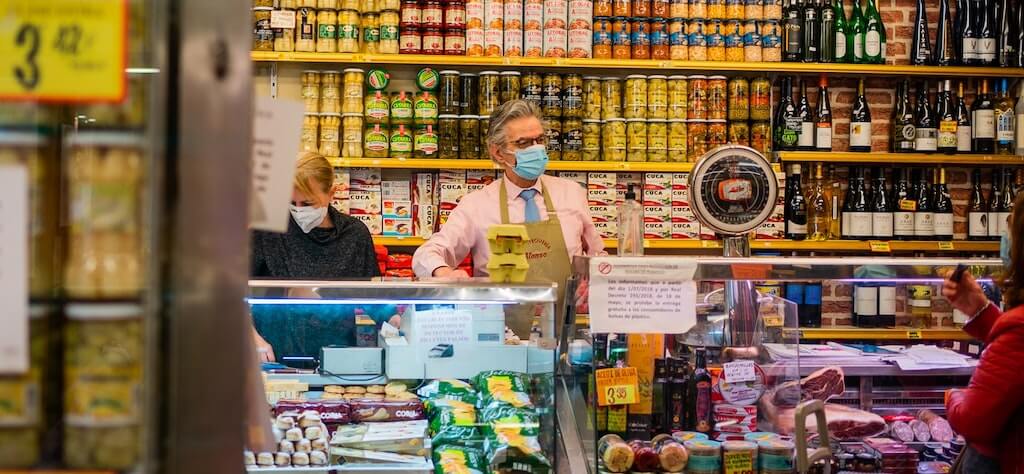 Homem atende mulher em mercadinho